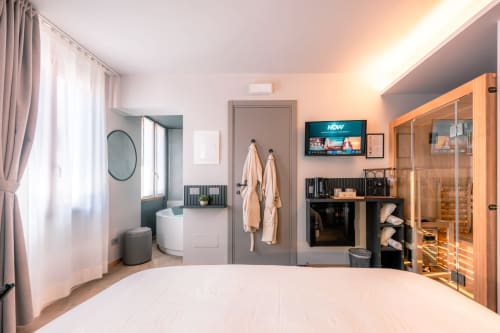 Camera moderna a Casa Giulietta a Sirmione con letto, bagno privato, TV, mobile contenitore in legno e vista sul lago