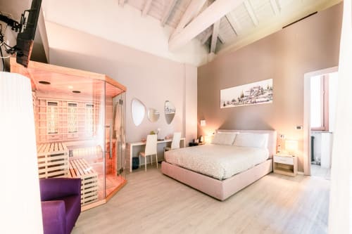 Camera Lilly a Casa Giulietta Como: camera da letto moderna con sauna, letto rosa, pavimenti in legno e scrivania