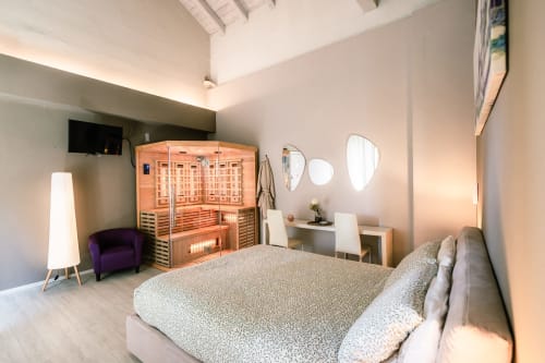 Camera Lilly presso Casa Giulietta Como con sauna, letto, poltrona viola e servizi moderni