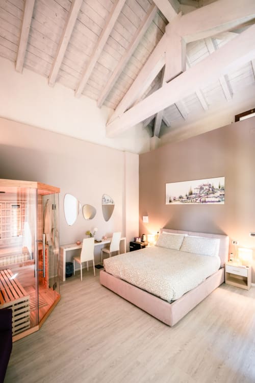 Camera Lilly a Casa Giulietta Como con letto rosa, travi a vista, sauna, specchi di vanità e pavimento in legno