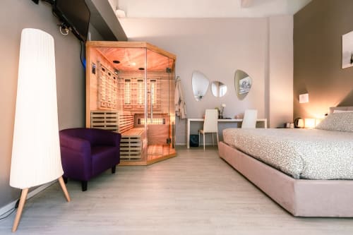 Camera Lilly presso Casa Giulietta Como con sauna, poltrona viola, letto, scrivania e servizi moderni
