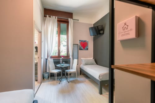 Accogliente camera OCEAN presso Casa Giulietta a Como, Italia, con letto, area living, TV e finestra con vista sulla città.