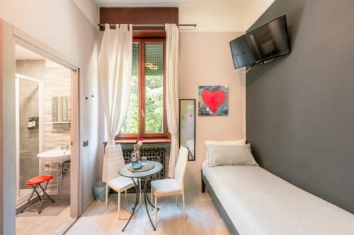 Camera Ocean Casa Giulietta a Como con letto, bagno, piccolo tavolo da pranzo e vista sulla città