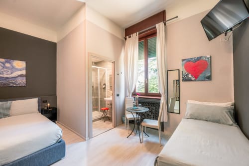 Moderna camera gemella dell'hotel Casa Giulietta a Como, Italia con vista sulla città, camino e arredamento contemporaneo