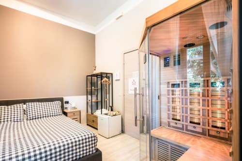 Camera moderna a Casa Giulietta Como con letto a quadri, armadio in legno e bagno con doccia interno