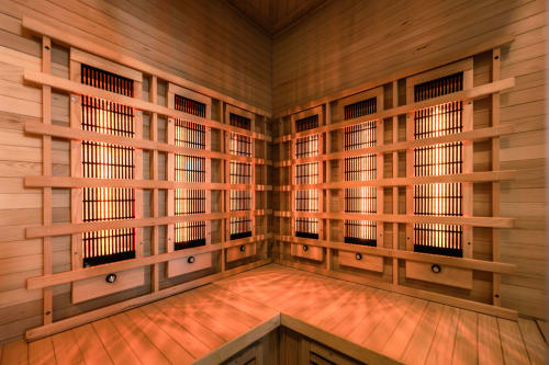 Interno accogliente di sauna in legno di cedro con panchine e porta in vetro a Casa Giulietta Como