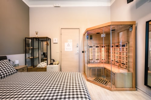 Camera moderna a Casa Giulietta Como con letto a quadri neri, sauna a infrarossi in legno e arredi contemporanei