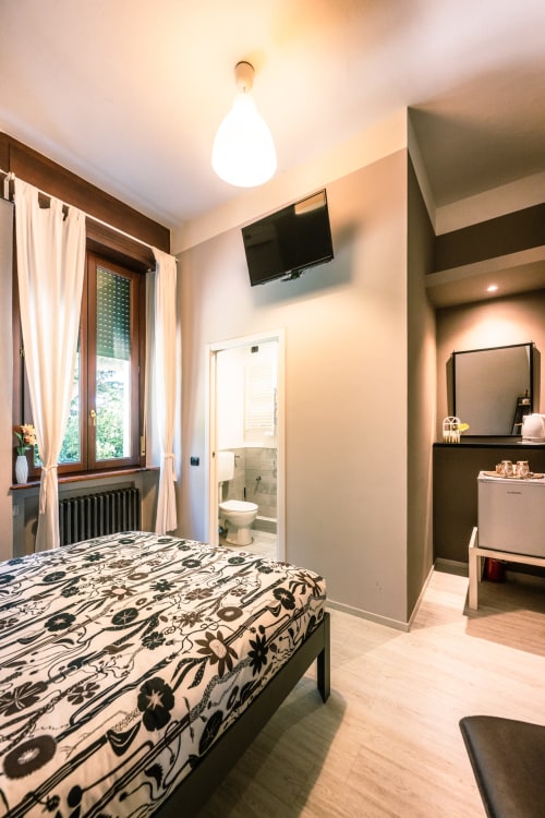 Camera Viola presso l'hotel Casa Giulietta Como con letto matrimoniale, bagno privato, TV e vista sul lago
