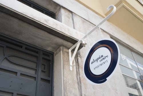 Sleep in Centre Apartments hanging sign in downtown Porto, Portugal with modern navy and copper design