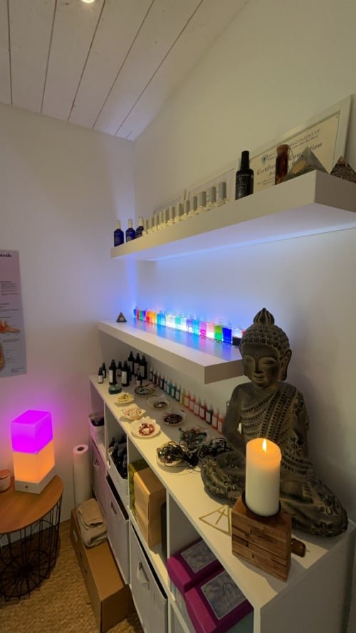 Étagère spa bien-être avec flacons colorés, statuette Bouddha, bougie et éclairage LED aux Papillons Des Sucs