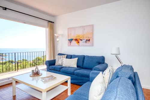 Salota moderna i lluminosa amb sofàs blaus amb vistes al Mediterrani a Finques Garcia Enrich, Palafrugell