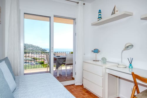Cambra costanera lluminosa a Finques Garcia Enrich amb vistes al mar, mobles blancs i decoració de temàtica mediterrània