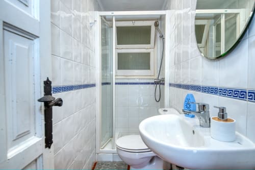 Bany modern a Finques Garcia Enrich, Palafrugell amb rajoles blanques, dutxa, lavabo i water