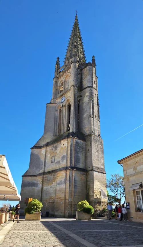 La tour en pierre d'une église historique sur la place du village de Saint-Émilion à La Maison du Clocher