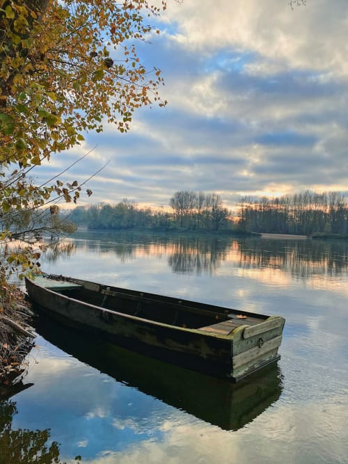 Bateau en bois amarré sur une rivière calme avec arbres d'automne, vallée de la Loire à Amboise