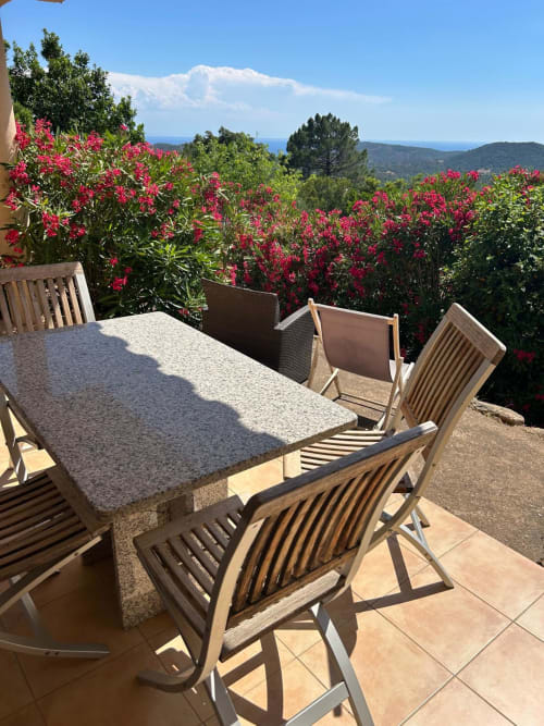 La terrasse L'Alba à Vista D'oro avec table à manger, vue sur mer et fleurs de bougainvillée magenta