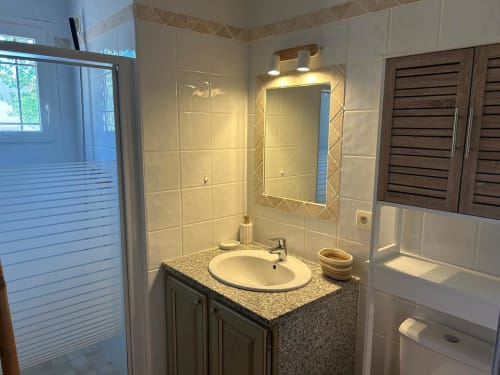 Salle de bain moderne à Vista D'oro avec lavabo, miroir, douche et meuble en bois dans la chambre L'Alba, Monacia d'Aullène