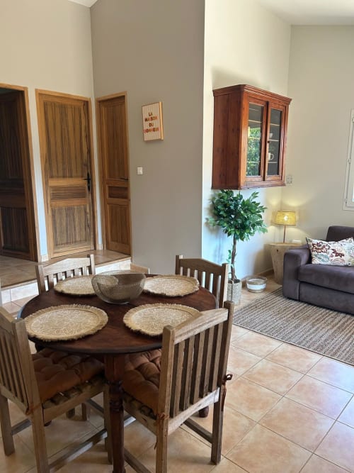 Salle à manger avec table ronde et sets de table en rotin dans la chambre Vista D'oro L'Alba, Monacia d'Aullène