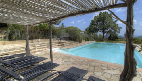 Espace piscine luxueux à Vista D'oro avec pergola en bois, transats et vue sur la mer à Monacia d'Aullène