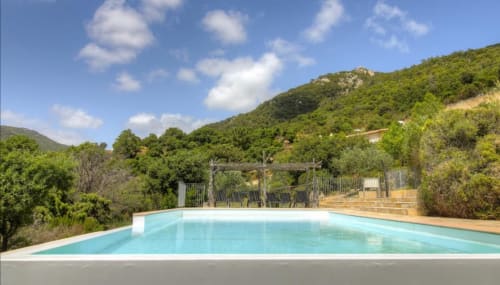 La piscine turquoise de Vista D'oro surplombe les collines luxuriantes de Monacia d'Aullène, Corse, avec espace détente et terrasse