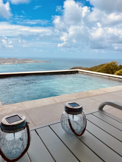 Piscine à débordement surplombant la mer des Caraïbes à Villa Nid des Colibris, Le Marin, Martinique avec lanternes solaires et vues côtières