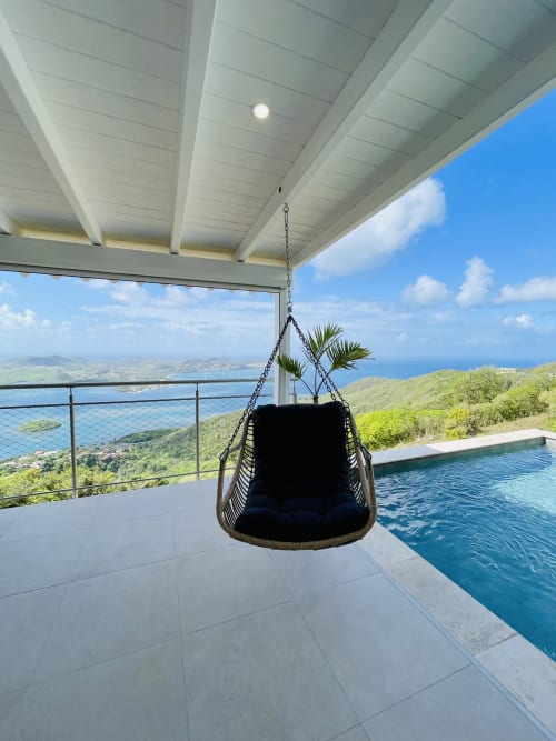 Chaise suspendue sous pergola moderne dominant la côte de la Martinique et la piscine à débordement de la Villa Nid des Colibris