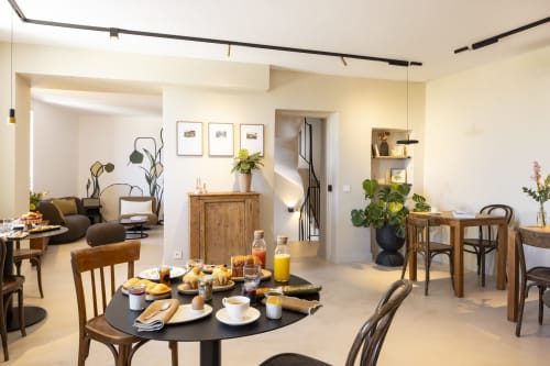 Salle à manger ouverte à La Maison des Jardins B&B à Gigondas avec petit-déjeuner, mobilier en bois et éclairage moderne.