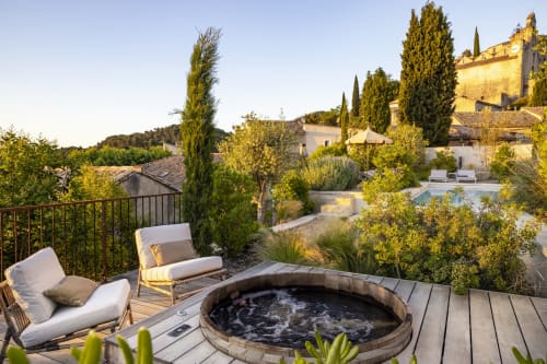 Terrasse luxueuse à La Maison des Jardins à Gigondas avec bain à remous, chaises longues et vue sur la campagne provençale