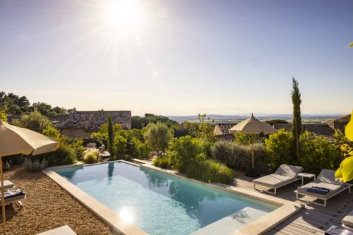 Piscine de La Maison des Jardins avec chaises longues, parasols et vue sur la campagne de Gigondas en Provence