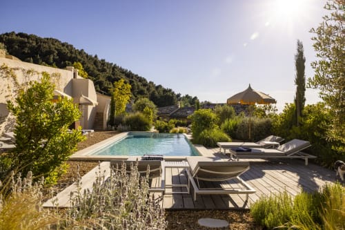 Élégante zone de piscine à La Maison des Jardins à Gigondas avec transats, parasol et jardins méditerranéens