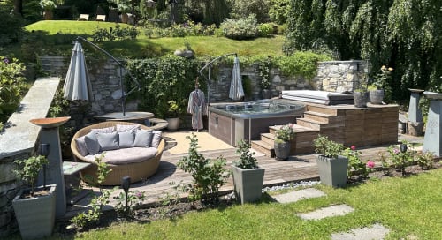 Luxus-Spa-Terrasse mit Rattanmöbeln, Whirlpool und gepflegten Gärten mit Blick auf den Lago Maggiore, Stresa.