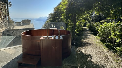 Holzbadewanne mit Seeblick im Luxus-Spa-Resort mit Blick auf den Lago Maggiore in Stresa, Italien