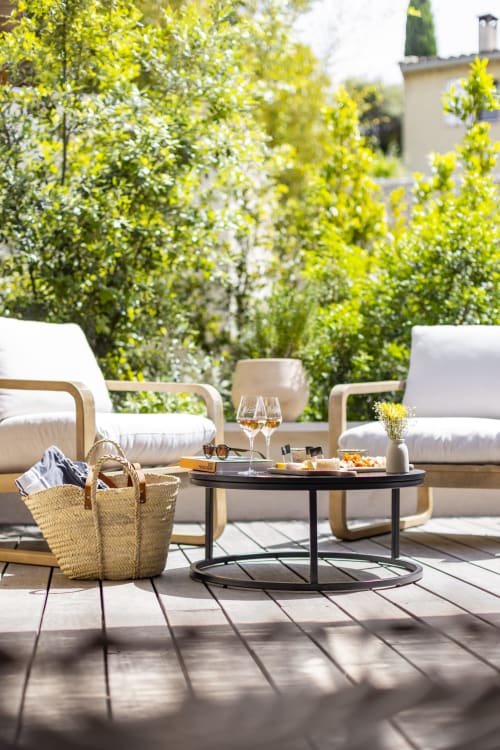 Terrasse ensoleillée à La Maison des Jardins avec salon de détente, verres de vin et verdure luxuriante à Gigondas