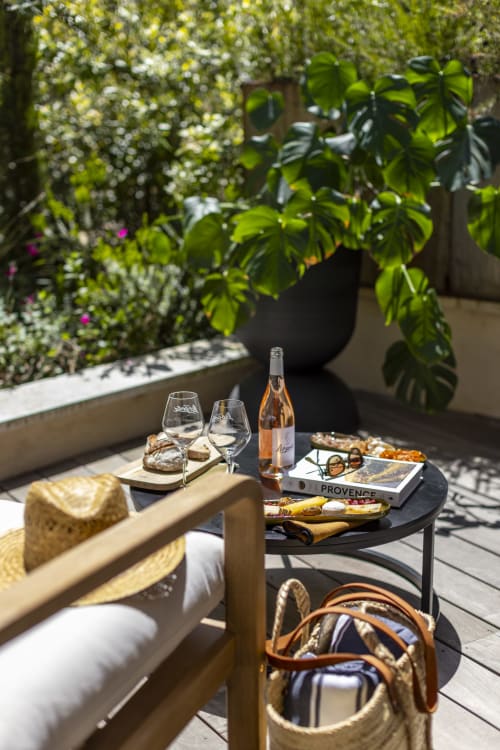 Terrasse de jardin provençal à La Maison des Jardins avec vin, fromage et décor de verdure luxuriante