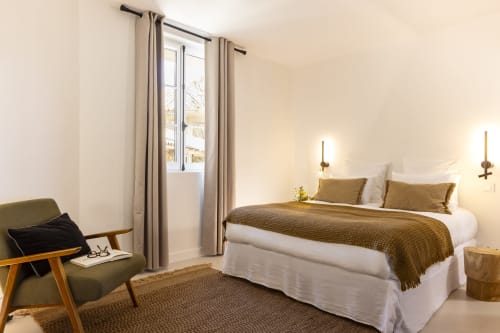 Chambre lumineuse à La Maison des Jardins à Gigondas avec lit queen-size, fauteuil olive et portes-fenêtres