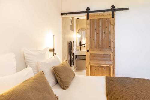 Chambre double de luxe à La Maison des Jardins B&B à Gigondas avec porte grange, coussins dorés et salle de bain attenante