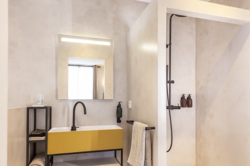 Salle de bain moderne à La Maison des Jardins à Gigondas avec lavabo jaune, robinetterie noire et douche à l'italienne