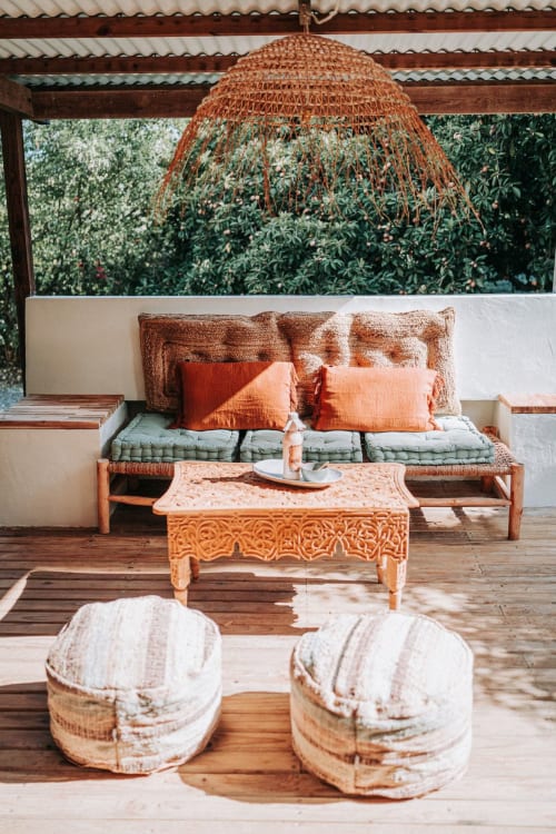 Terrasse de villa balnéaire au Bleu Guesthouse Saint-Francois avec mobilier tressé, coussins corail et vue sur l'océan