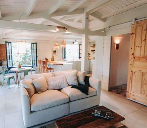 Intérieur lumineux de la villa Bleu Guesthouse à Saint-François : canapé crème, poutres apparentes et accents en bois naturel