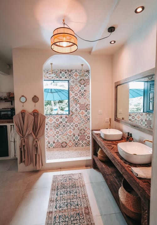 Salle de bain de la suite Bleu Céladon au Bleu Guesthouse avec double vasque, carrelage à motifs et vue sur la piscine