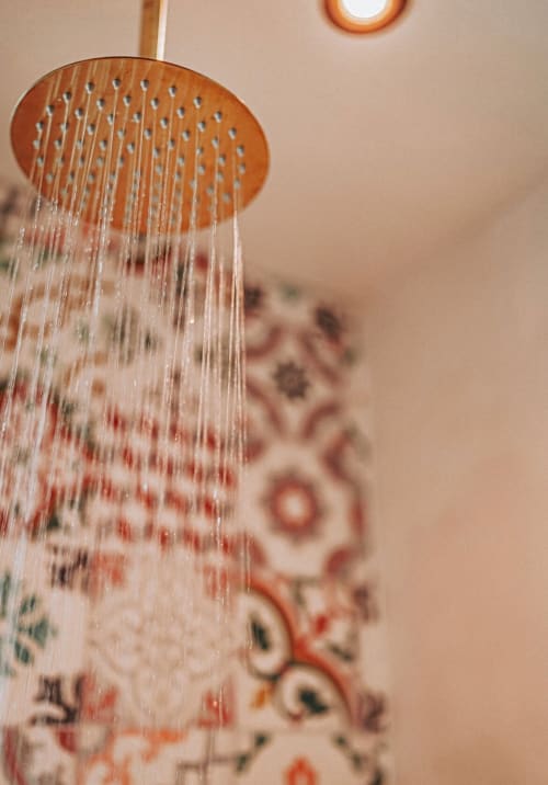 Pommeau de douche à effet pluie avec eau qui coule dans une salle de bain moderne de la Bleu Guesthouse, Saint-François
