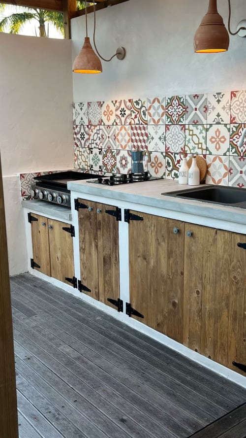 Cuisine extérieure moderne au Bleu Guesthouse avec meubles en bois, dosseret en carrelage motifs et luminaires suspendus en cuivre