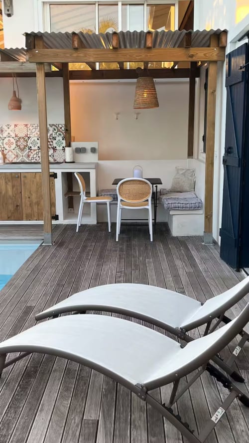 Terrasse de la Suite Bleu Céladon du Bleu Guesthouse avec pergola repas, terrasse bois et transats vue piscine