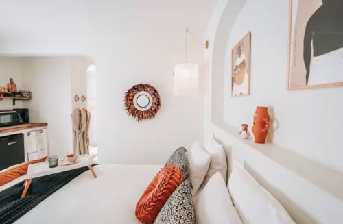 Suite Bleu Céladon de Bleu Guesthouse à Saint-François : intérieur d'appartement moderne blanc avec accents orangés, cuisine et