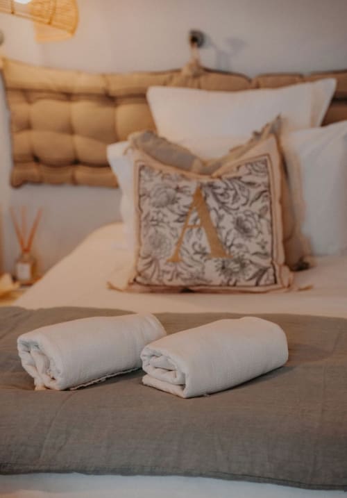 Chambre Suite Bleu Azur avec lit garni de serviettes roulées, coussins décorables et literie naturelle