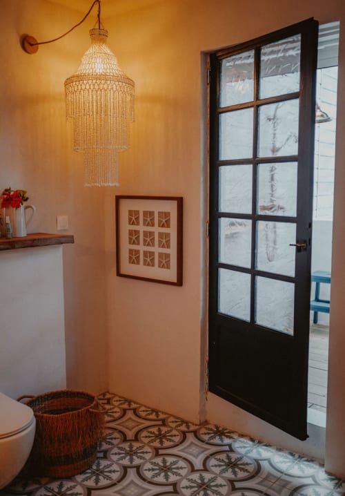 Salle de bains Suite Bleu Azur du Bleu Guesthouse avec lustre à perles, carrelage décoratif et portes-fenêtres noires