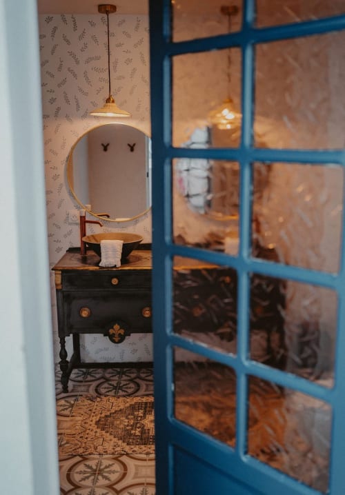 Salle de bains de la Suite Bleu Azur avec miroir rond et ancien meuble noir à Saint-François