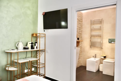 Deluxe room 402 presso Taga Rooms Catania con TV a schermo piatto, scrivania in legno e bagno privato con scaldasalviette