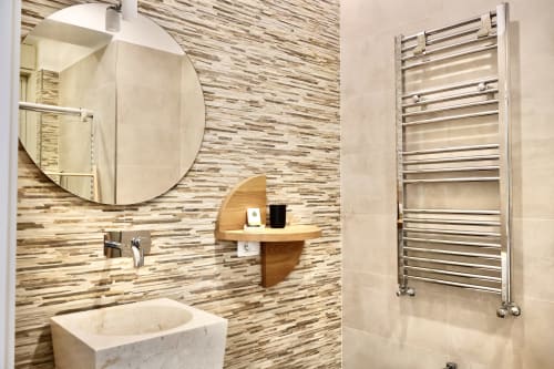 Bagno moderno in Taga Rooms Catania con lavabo in marmo, rivestimento piastrellato a righe, specchio rotondo, ripiano in legno e scaldasalviette