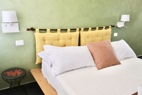 Camera deluxe di Taga Rooms Catania con testata gialla, biancheria bianca e pareti verde salvia